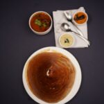 Top view of a South Indian dosa meal with chutneys and sambar