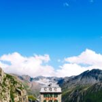 A hotel set among mountains under a clear blue sky