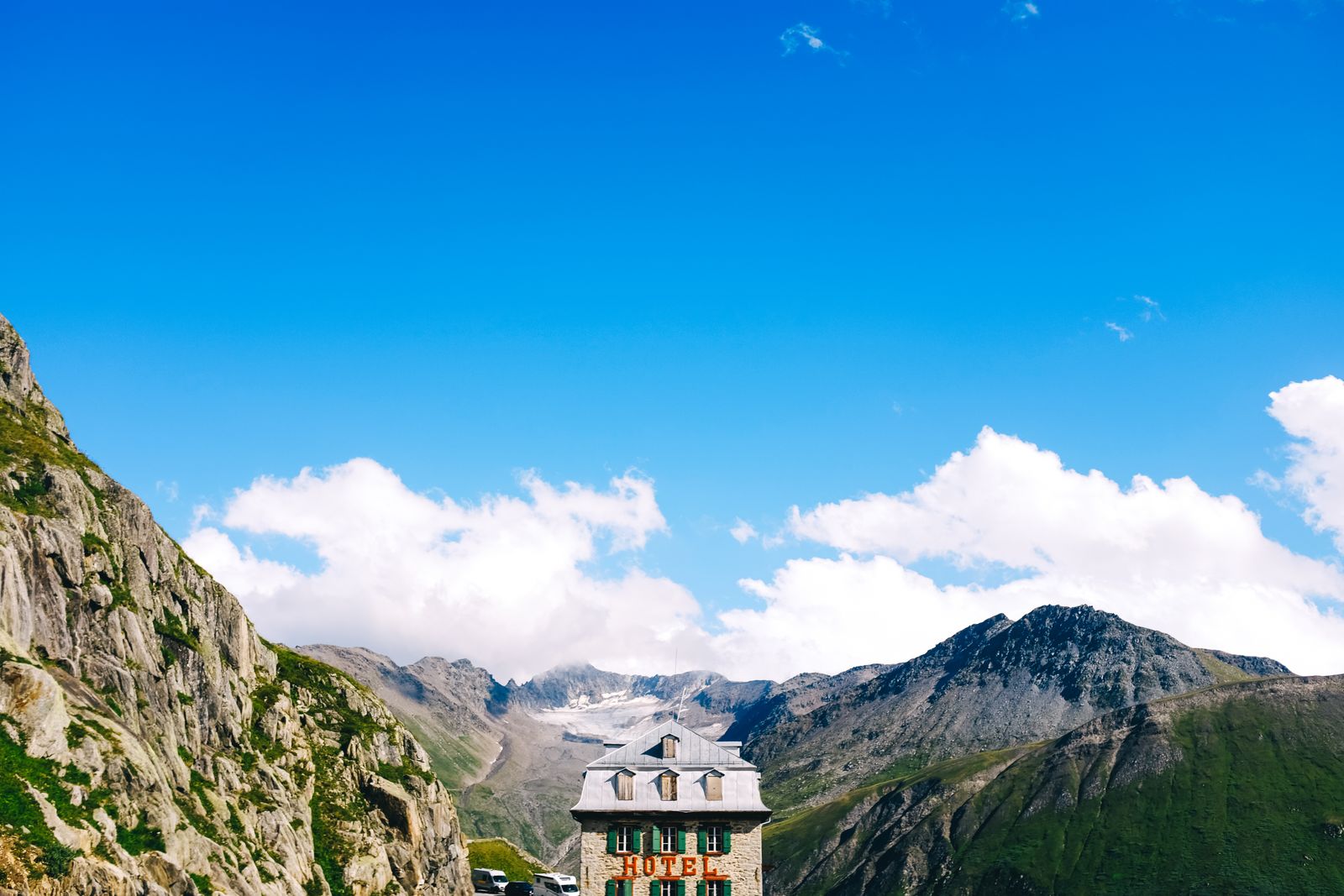 A hotel set among mountains under a clear blue sky